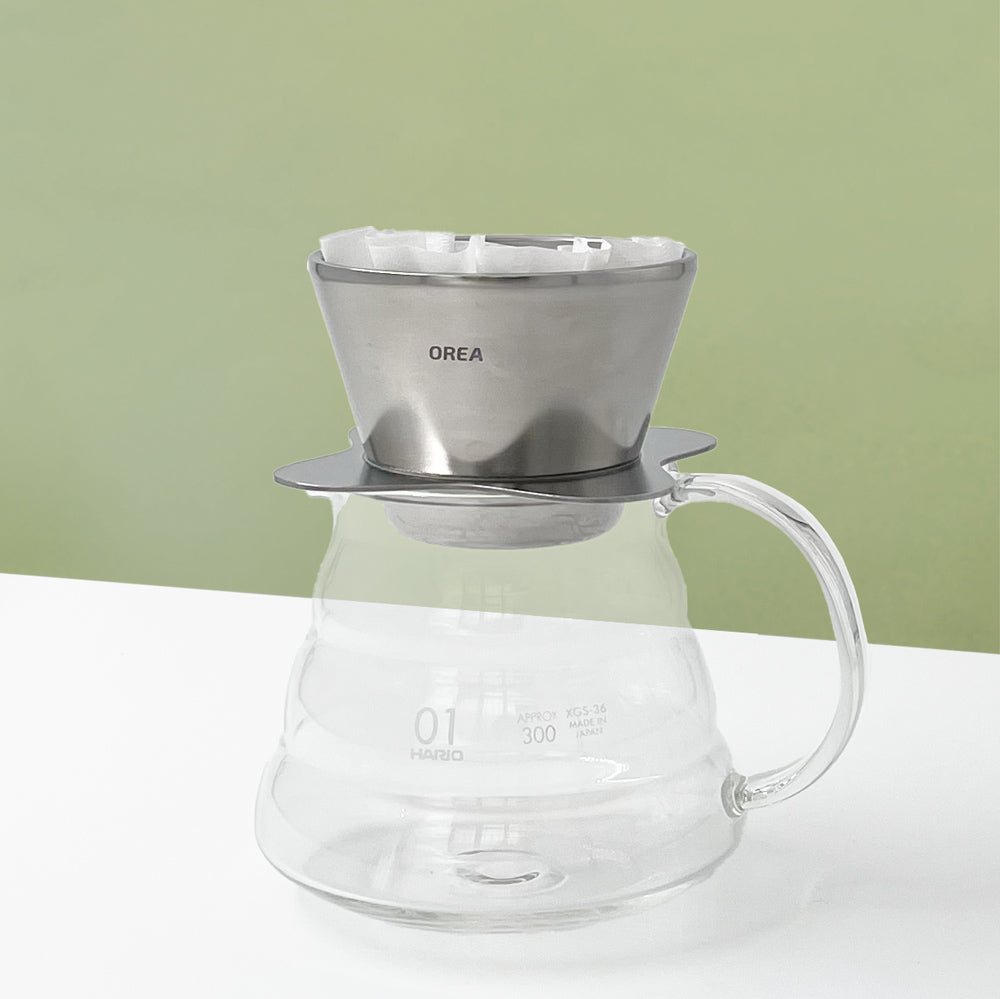 Orea O1 Brewer Raw Steel posé sur une carafe avec filtre plat 155 Small pendant une extraction café filtre